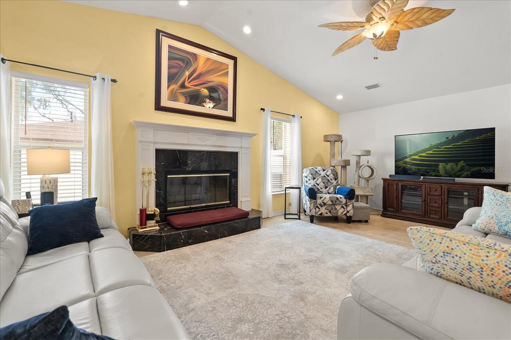 1254 Timberidge Loop South Lakeland, FL 33809 - Photo 4 of 36 a living room with furniture a fireplace and a flat screen tv
