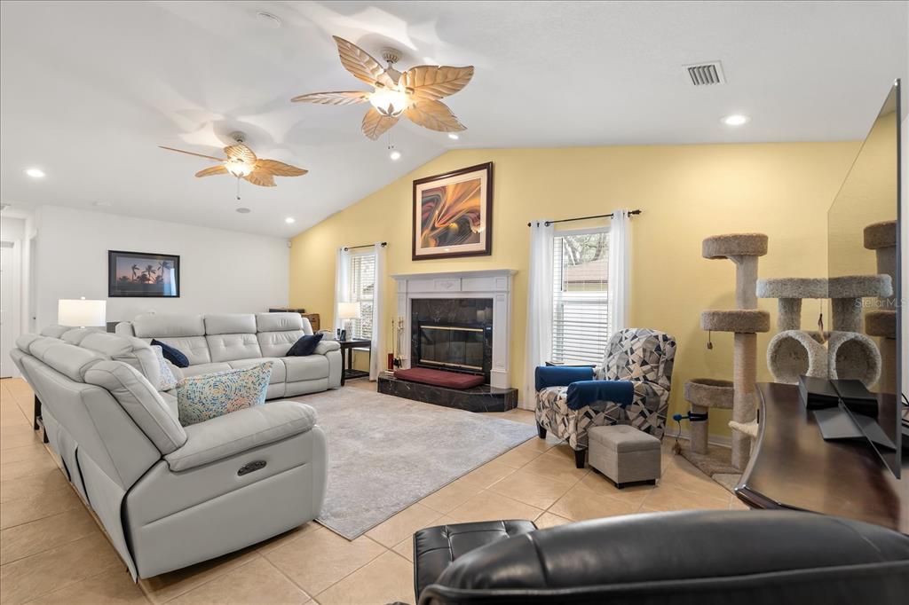 1254 Timberidge Loop South Lakeland, FL 33809 - Photo 6 of 36 a living room with furniture a fireplace and a chandelier