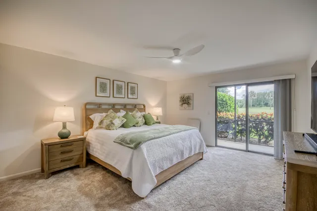 a bedroom with a bed and a flat tv screen on dresser