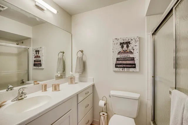 a bathroom with a toilet sink shower and mirror