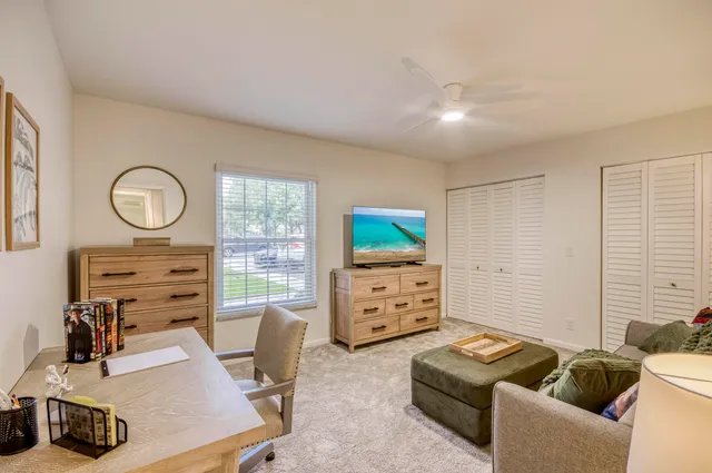 a room with furniture a flat screen tv and a window