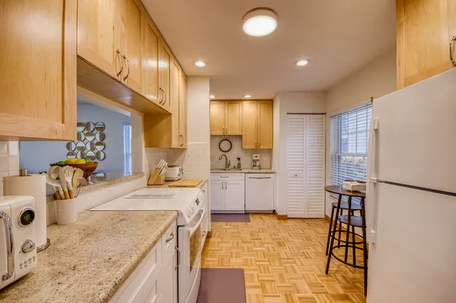 a large kitchen with stainless steel appliances granite countertop a sink and a refrigerator