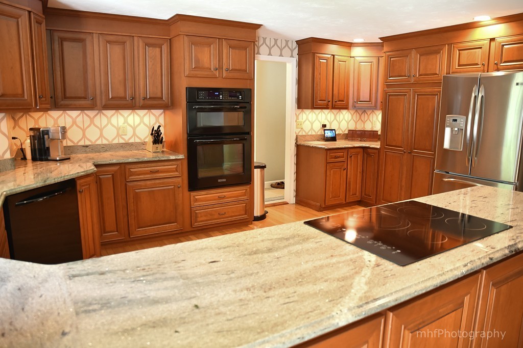 82 Cranberry Circle Sudbury, MA 01776 - Photo 13 of 30 a kitchen with stainless steel appliances kitchen island granite countertop a refrigerator stove and sink