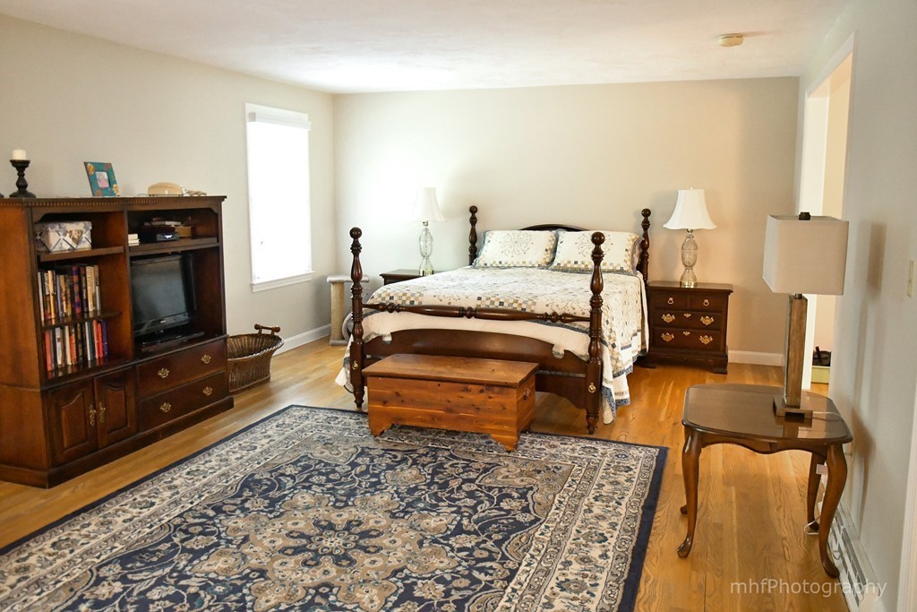 82 Cranberry Circle Sudbury, MA 01776 - Photo 23 of 30 a bedroom with a bed and wooden floor