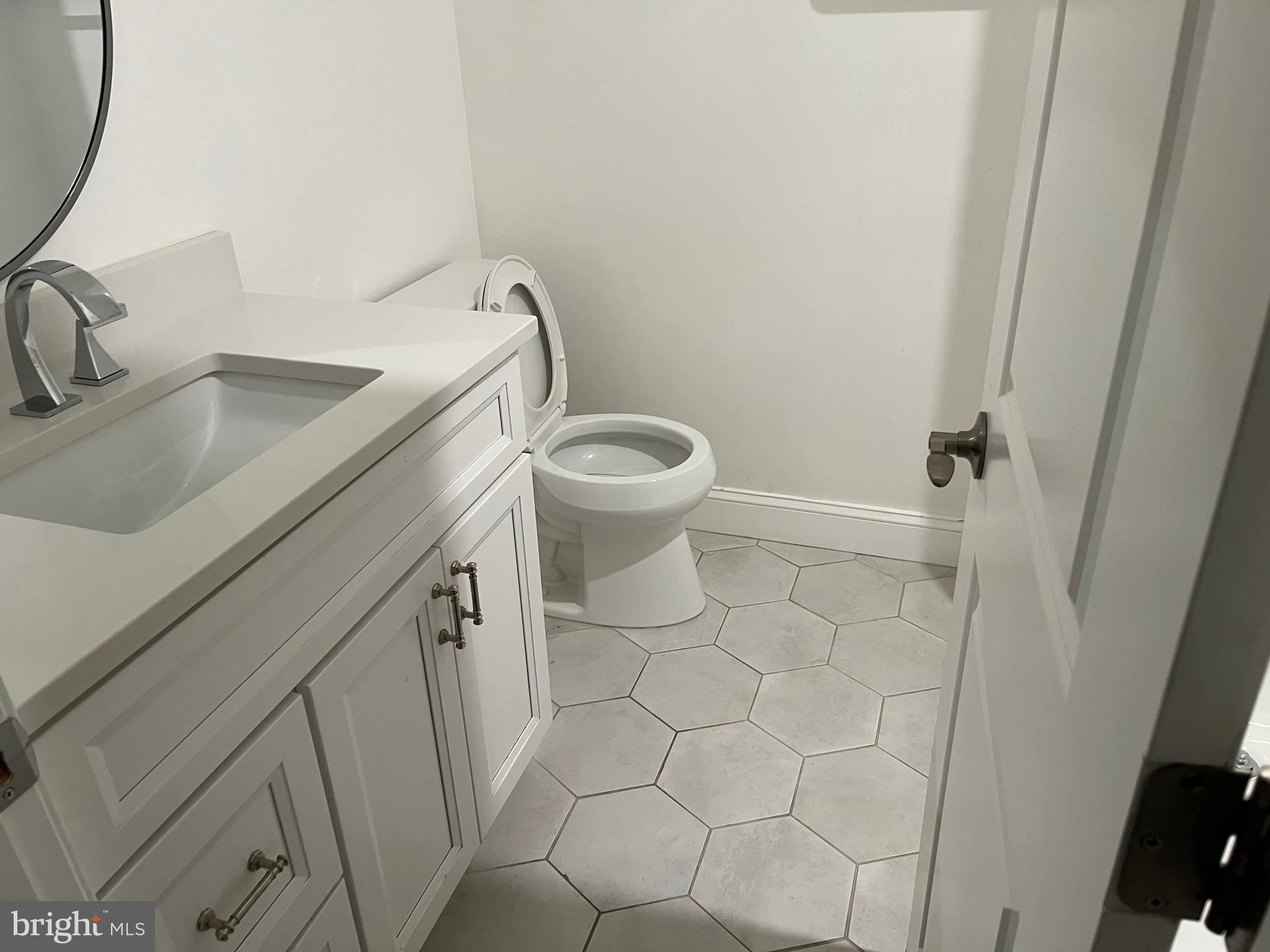 611 Winona Court Silver Spring, MD 20902 - Photo 13 of 15 a bathroom with a sink a toilet and a mirror