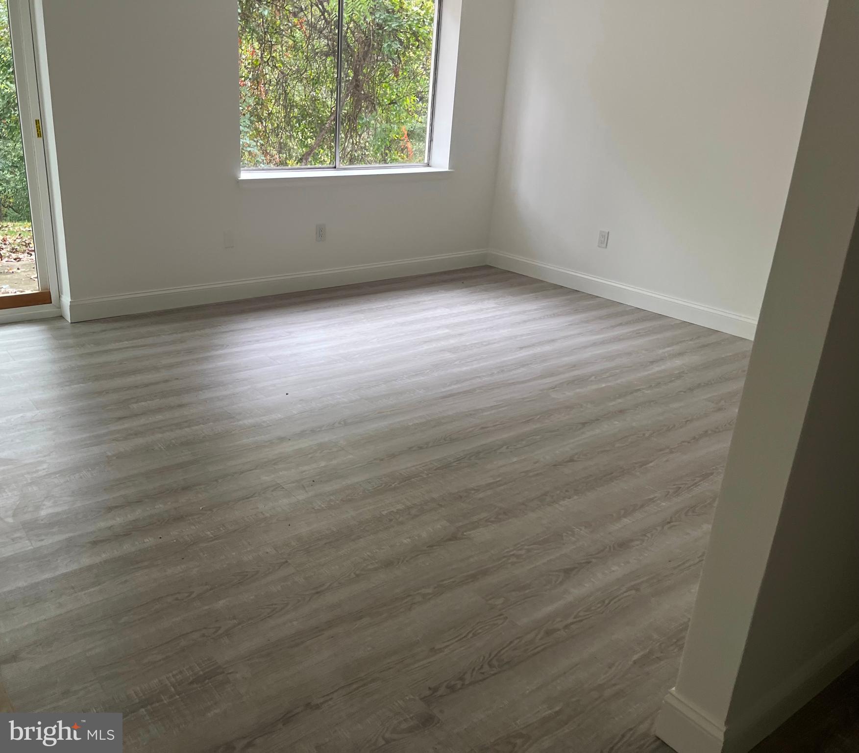 611 Winona Court Silver Spring, MD 20902 - Photo 5 of 15 an empty room with wooden floor and windows