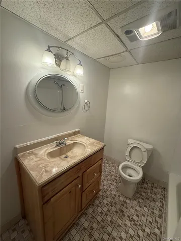 a bathroom with a granite countertop sink toilet and a mirror