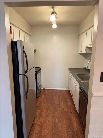 a kitchen with granite countertop a refrigerator a sink a stove a washer and dryer