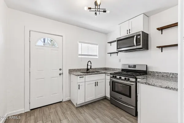 a kitchen with stainless steel appliances a white stove top oven and sink
