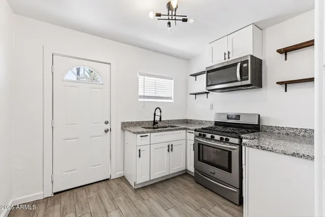 a kitchen with stainless steel appliances a white stove top oven and sink