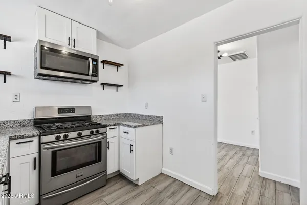 a kitchen with stainless steel appliances a stove a microwave and sink