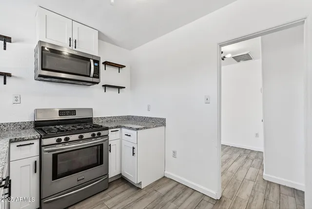 a kitchen with stainless steel appliances a stove a microwave and sink