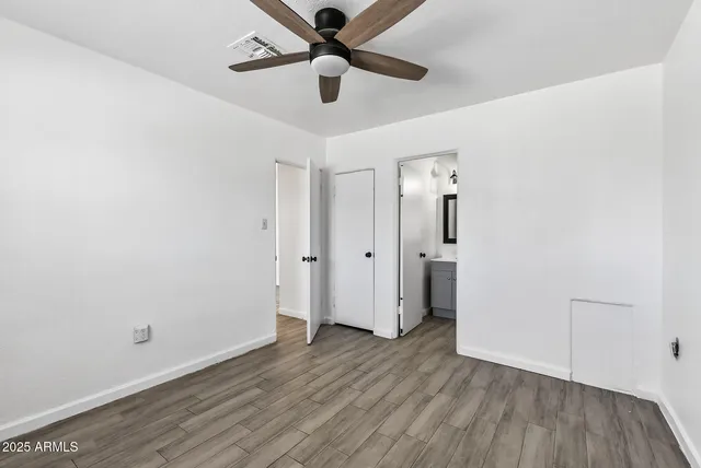 an empty room with wooden floor a ceiling fan and closet