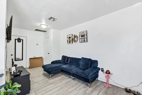 a living room with furniture a flat screen tv and a window