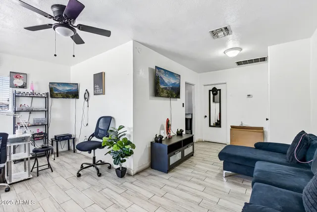 a living room with furniture and a wooden floor