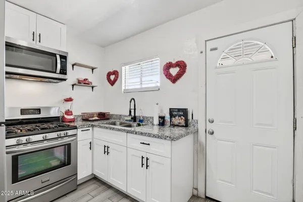 a kitchen with stainless steel appliances granite countertop a refrigerator and a stove top oven