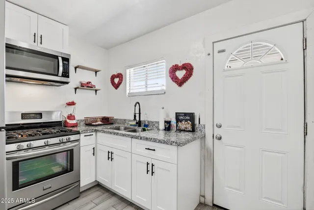 a kitchen with stainless steel appliances granite countertop a refrigerator and a stove top oven