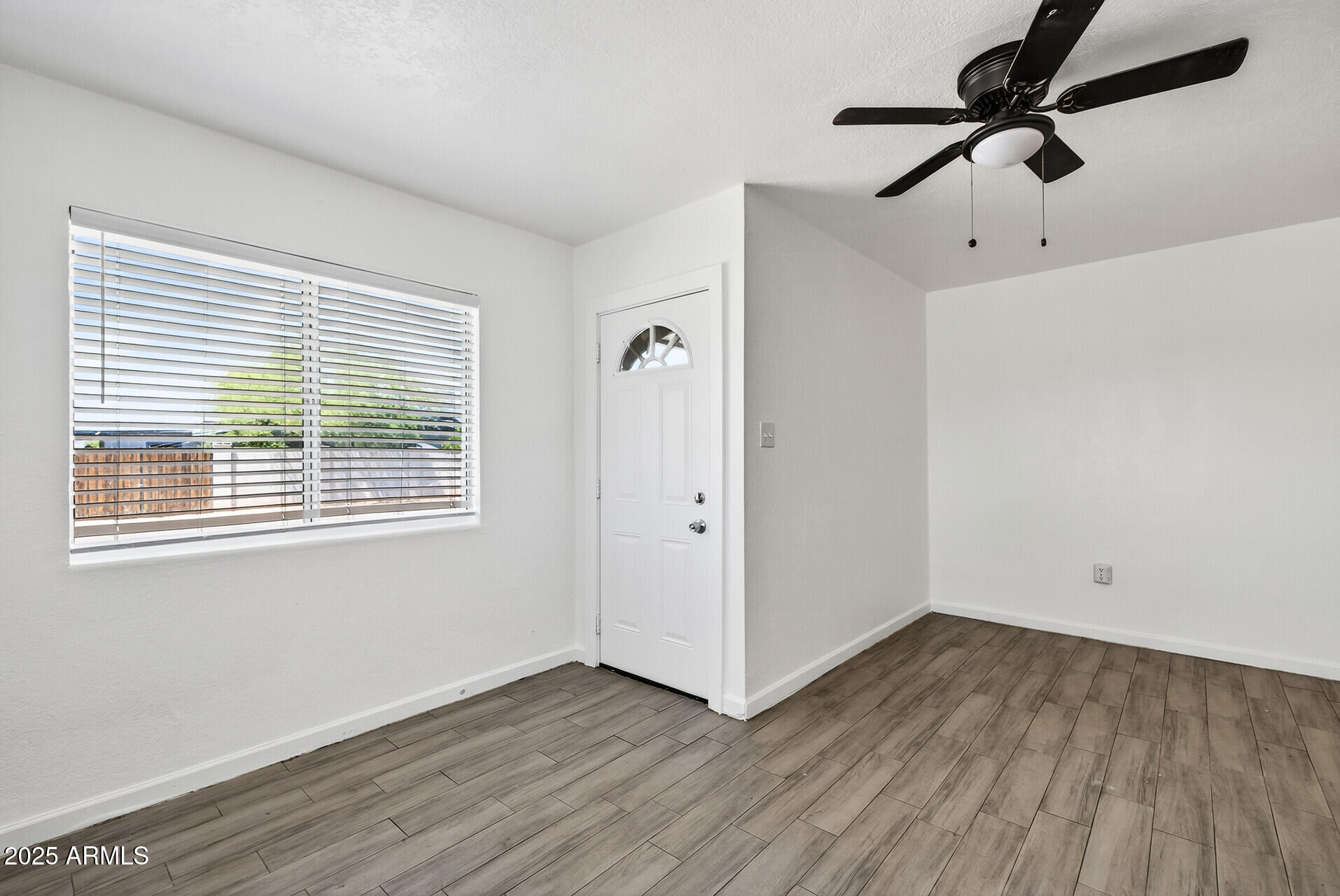 107 West 11th Street Casa Grande, AZ 85122 - Photo 10 of 45 a view of an empty room with wooden floor and a window