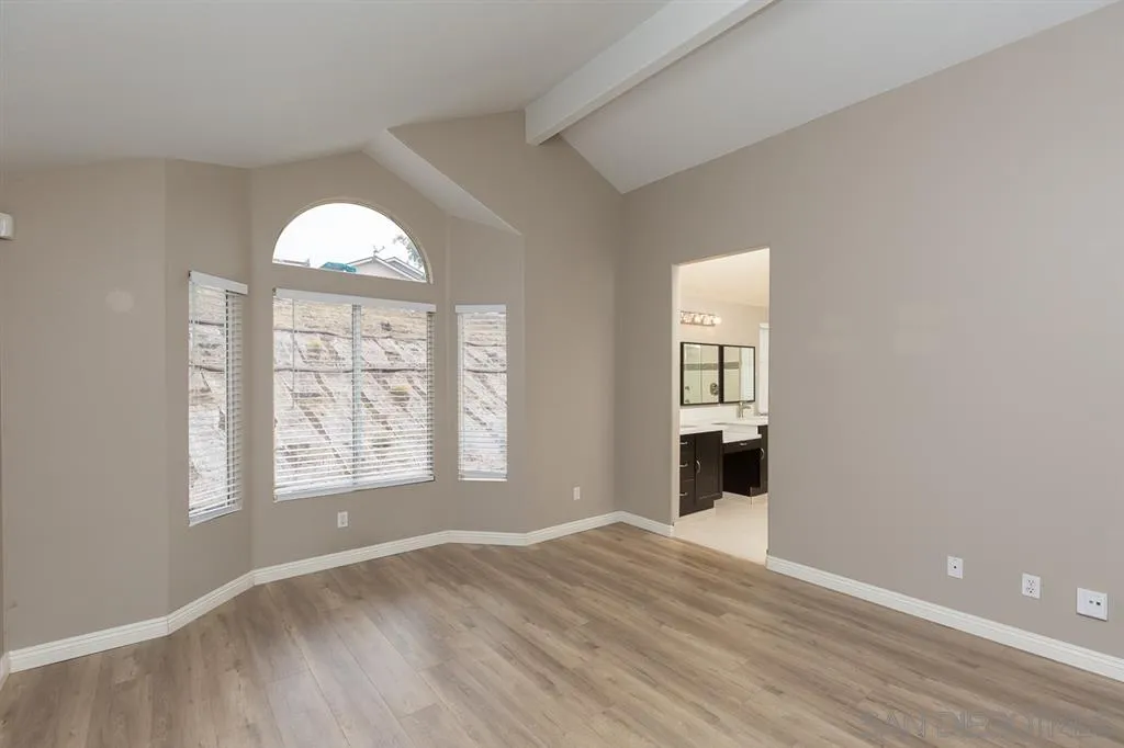 555 Kiley Road Chula Vista, CA 91910 - Photo 13 of 24 an empty room with wooden floor cabinet and windows