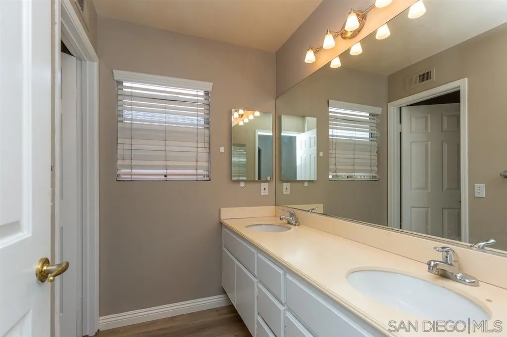 555 Kiley Road Chula Vista, CA 91910 - Photo 18 of 24 a bathroom with a granite countertop sink a mirror and a vanity