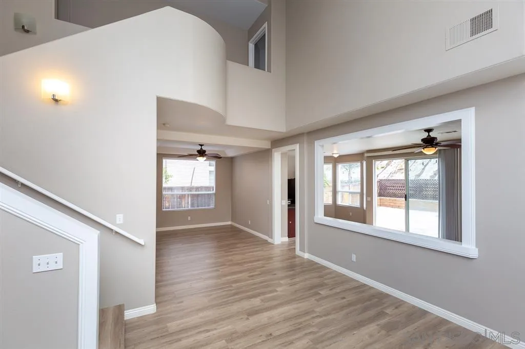 555 Kiley Road Chula Vista, CA 91910 - Photo 3 of 24 a view of an empty room with wooden floor and a window