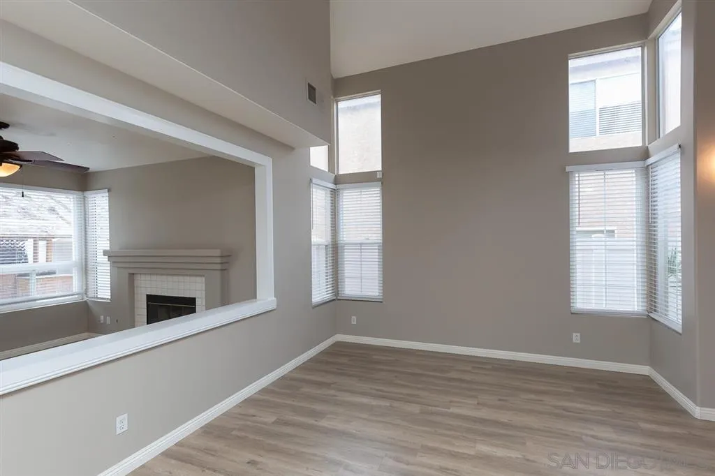 555 Kiley Road Chula Vista, CA 91910 - Photo 5 of 24 an empty room with wooden floor fireplace and windows