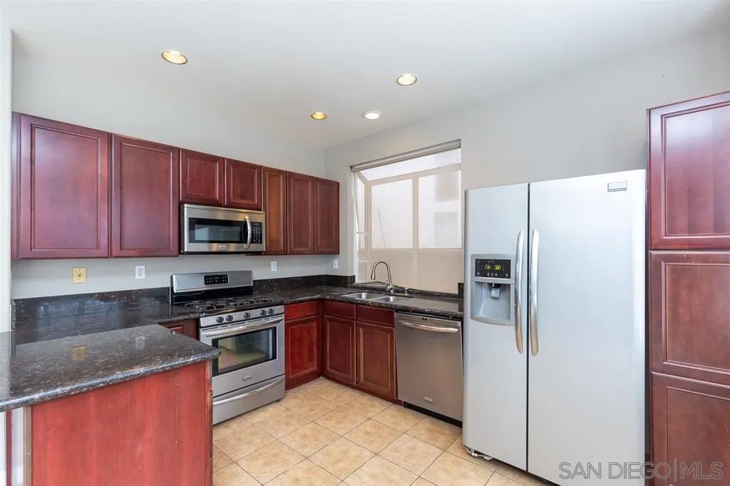 555 Kiley Road Chula Vista, CA 91910 - Photo 8 of 24 a kitchen with stainless steel appliances granite countertop a stove top oven a refrigerator a sink and dishwasher