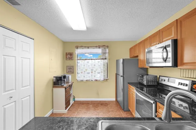 a kitchen with stainless steel appliances granite countertop a refrigerator and a stove