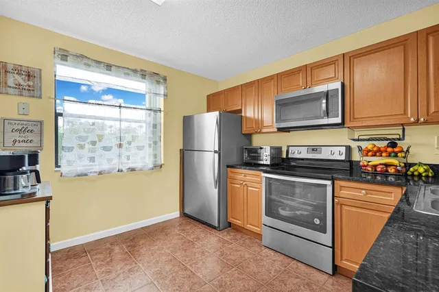 a kitchen with stainless steel appliances granite countertop a refrigerator stove and microwave