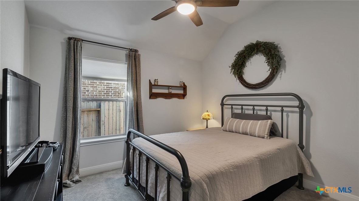 1816 Field Brook Seguin, TX 78155 - Photo 25 of 32 a bedroom with a bed and a large mirror with a chandelier