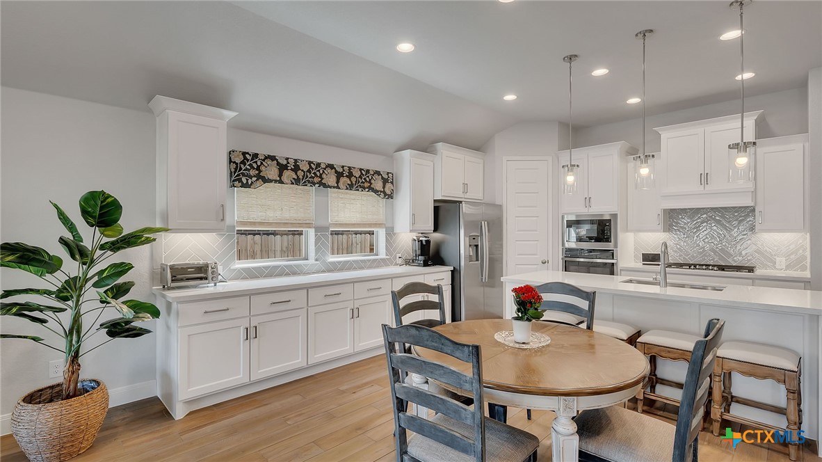 1816 Field Brook Seguin, TX 78155 - Photo 4 of 32 a kitchen with stainless steel appliances a table and chairs in it