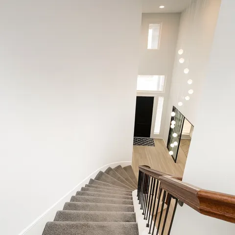 a view of a hallway with wooden floor and staircase