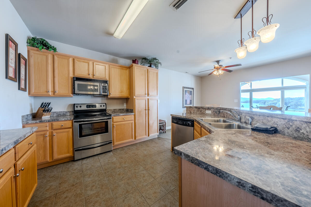 1217 Graves Harbor Trail, Unit 144 Huddleston, VA 24104 - Photo 15 of 30 a kitchen with kitchen island granite countertop a stove top oven a sink a counter space and cabinets