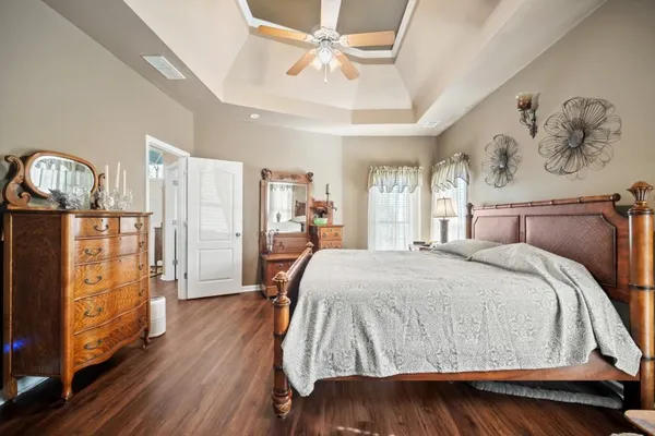 a spacious bedroom with a bed mirror and window