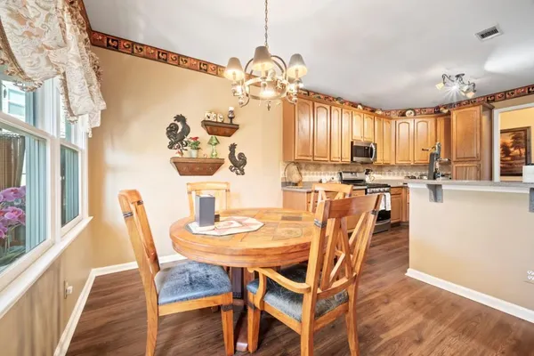 a dining room with furniture a chandelier and wooden floor