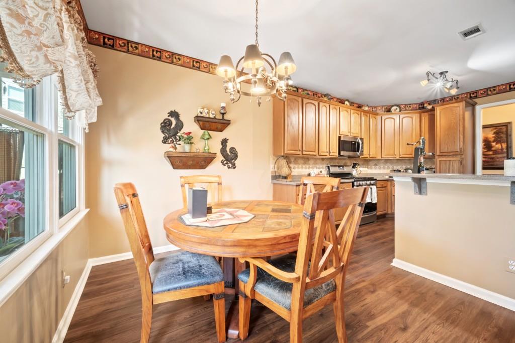 348 Mountain Laurel Walk Canton, GA 30114 - Photo 7 of 26 a dining room with furniture a chandelier and wooden floor