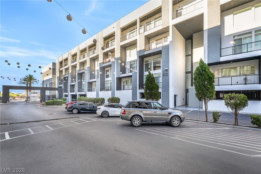 2775 West Pebble Road, Unit 505 Las Vegas, NV 89123 - Photo 2 of 26 A modern multi-level building features private balconies and a secure gated entrance.