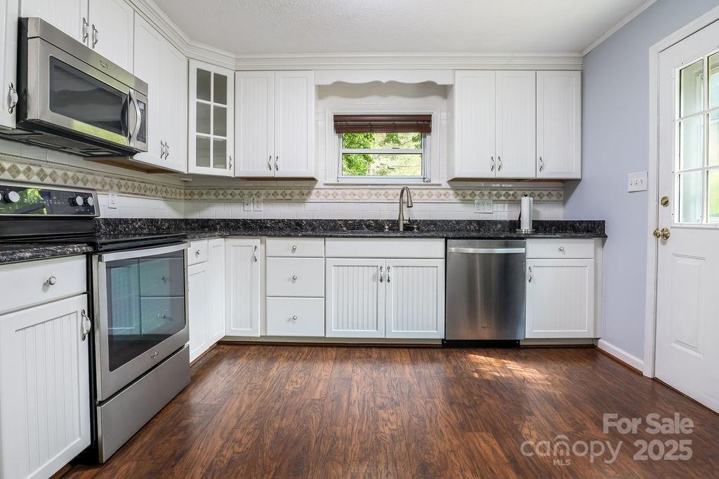 3 Stockwood Road Asheville, NC 28803 - Photo 3 of 36 a kitchen with stainless steel appliances granite countertop wooden floors and sink