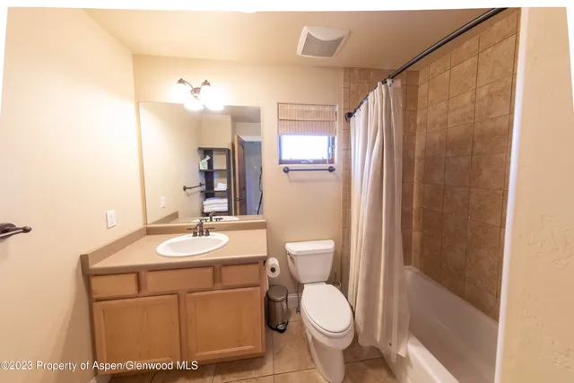 a bathroom with a sink a toilet a mirror and shower