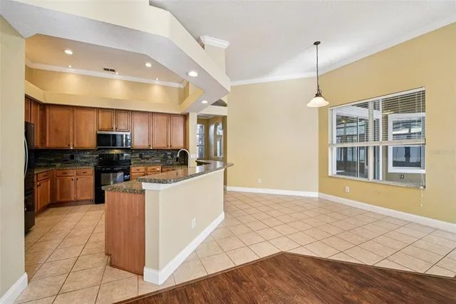 a kitchen with stainless steel appliances granite countertop a stove top oven a sink a counter space and cabinets