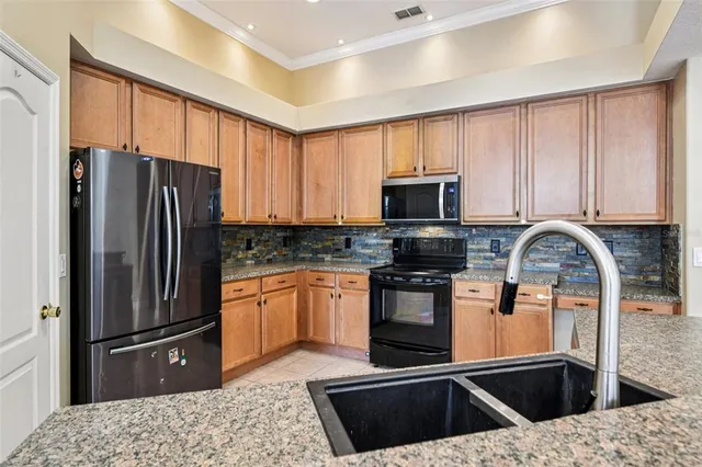 a kitchen with stainless steel appliances granite countertop a refrigerator stove and microwave