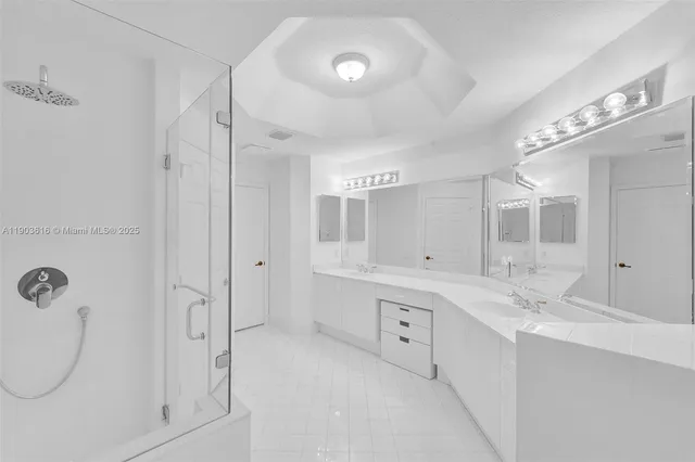 a spacious bathroom with a double vanity sink a mirror and a shower