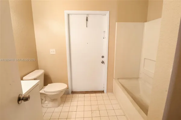 a bathroom with a granite countertop shower and a toilet