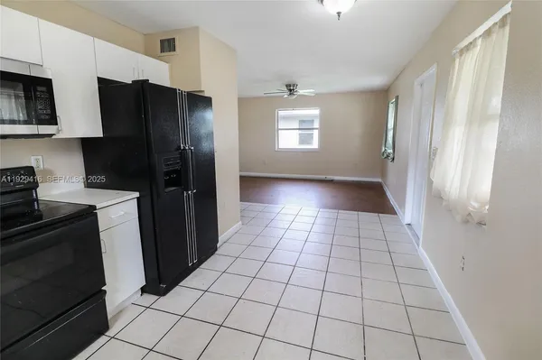 a kitchen with a refrigerator a stove top oven and cabinets