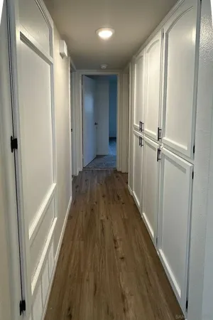 a view of a hallway with wooden floor