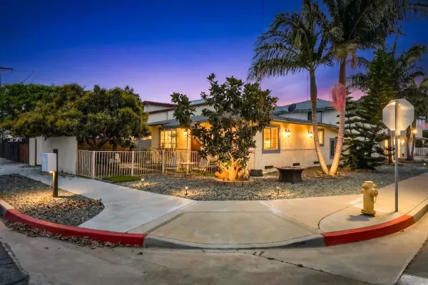 a view of a house with a small yard and potted plants