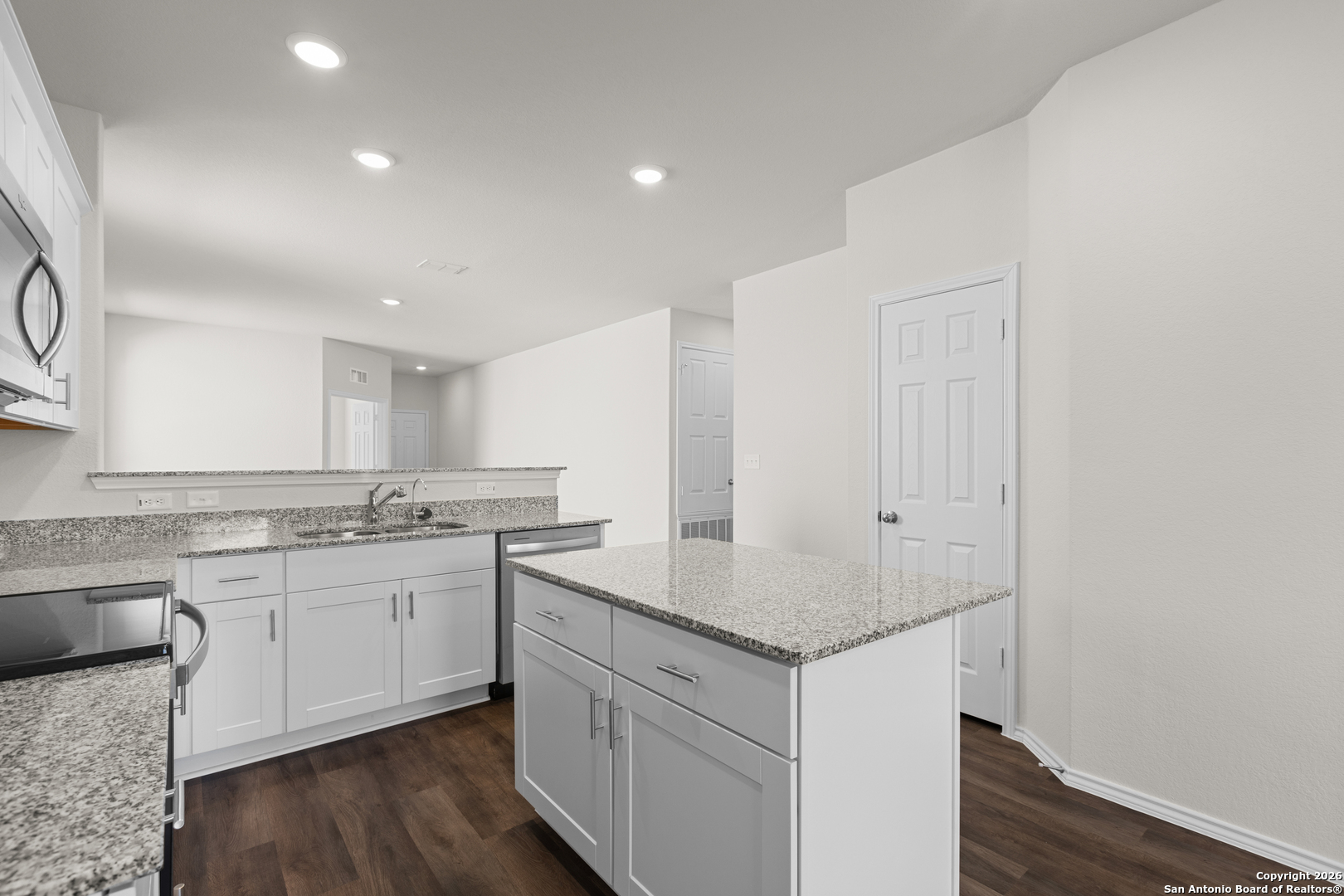4137 Bermuda Lane Seguin, TX 78155 - Photo 16 of 24 a kitchen with a sink dishwasher a stove and white cabinets with wooden floor