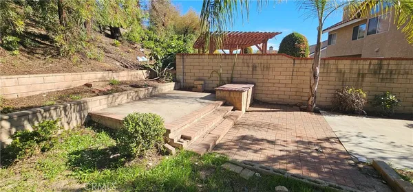 a view of a chair and table in backyard of the house