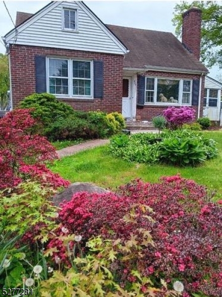a front view of house with yard and flowers