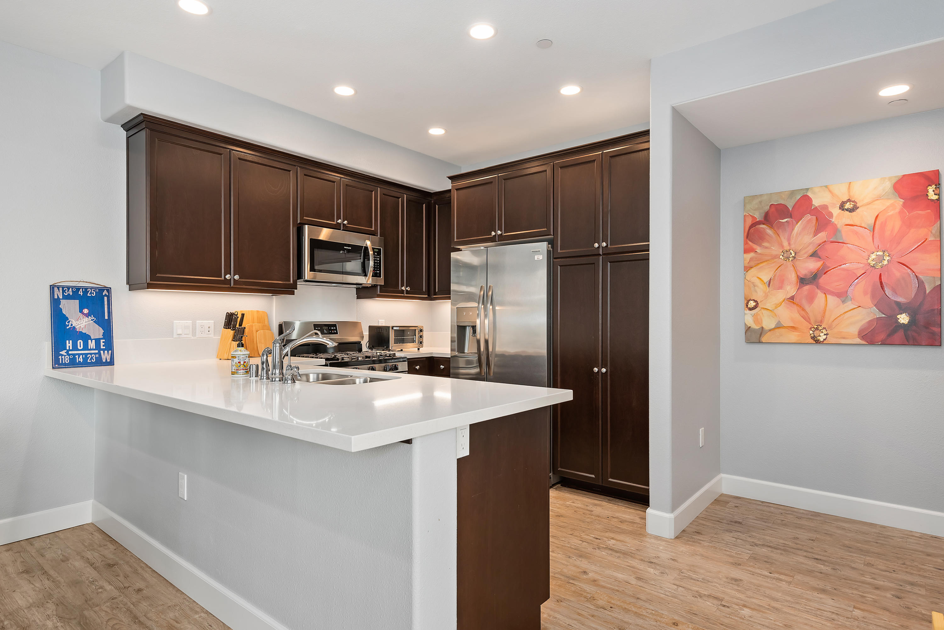 242 Robles Way Buellton, CA 93427 - Photo 5 of 25 a kitchen with stainless steel appliances granite countertop a refrigerator stove a sink and dishwasher with wooden floor